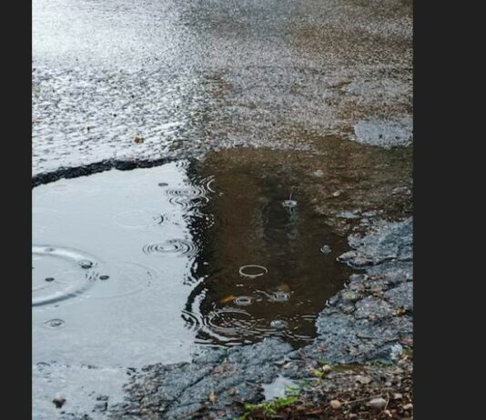 Pothole filled with water from falling rain.