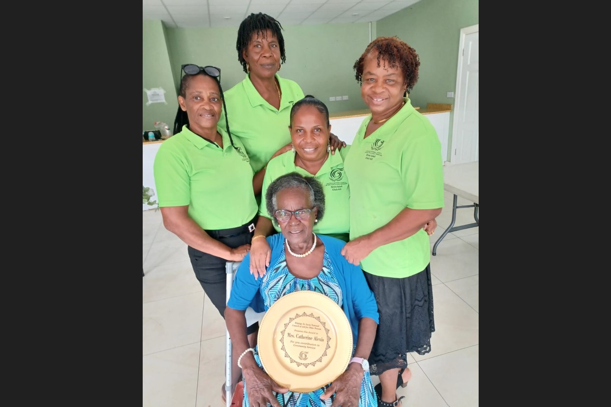 Gros Islet honouree Catherine Alexis holds plaque while surrounded by well-wishers.