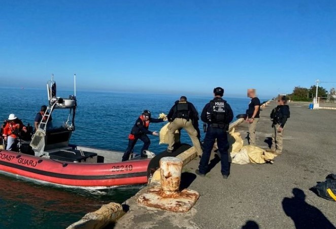 Cocaine seized in the Caribbean Sea being offloaded by Coast Guard officials.