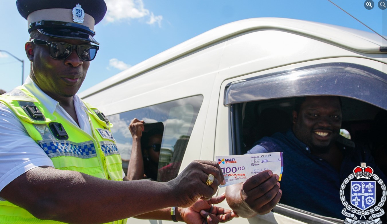 A police officer presents a gist voucher to a motorist.