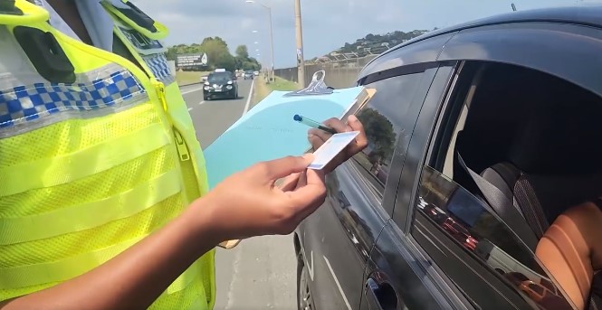 Police officer examines a driver's licence while conducting a traffic check.