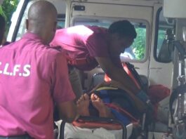 Emergency personnel tend to a victim on a stretcher in an ambulance after a road accident at Grace, Vieux Fort.