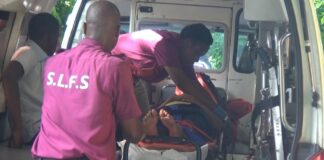 Emergency personnel tend to a victim on a stretcher in an ambulance after a road accident at Grace, Vieux Fort.