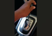 Hand on automatic transmission gear lever.