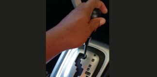 Hand on automatic transmission gear lever.