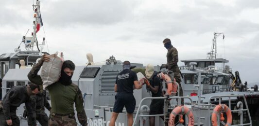 French Navy officials remove confiscated drugs from a vessel.