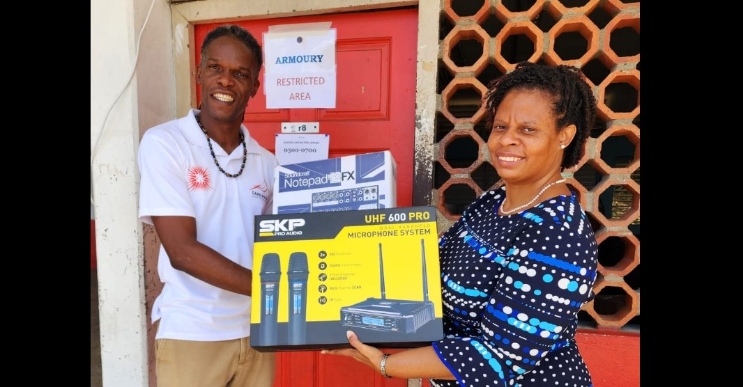 hop Director of the Castries Comprehensive Seondary School, Michael Peterkin, accepts a Public Address System, on behalf of the school, from Project Officer at the RSS, Elizabeth Bradshaw.