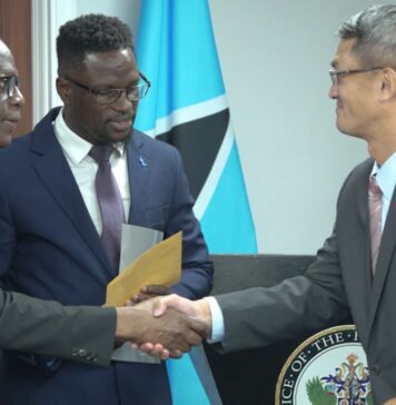 Prime Minister Philip J. Pierre and Taiwan Ambassador Peter Chen shake hands at handover of CDP funds.