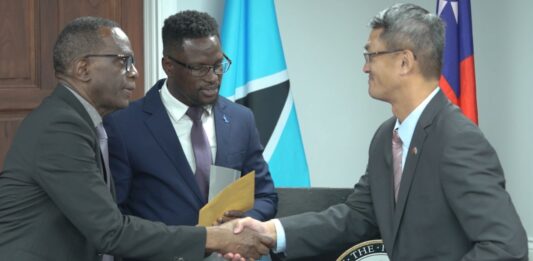 Prime Minister Philip J. Pierre and Taiwan Ambassador Peter Chen shake hands at handover of CDP funds.