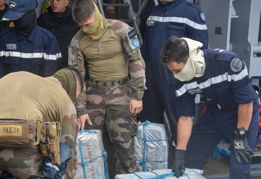 French sailors unload bales of cocaine.