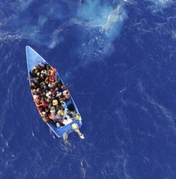 Illegal Caribeban migrants in grossly overloaded makeshift boat at sea.