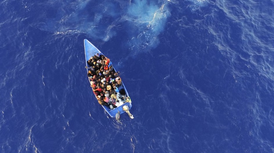 Illegal Caribeban migrants in grossly overloaded makeshift boat at sea.