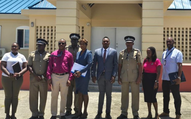 Jeremiah Norbert and other officials pose for photo outside Vieux Fort police station.