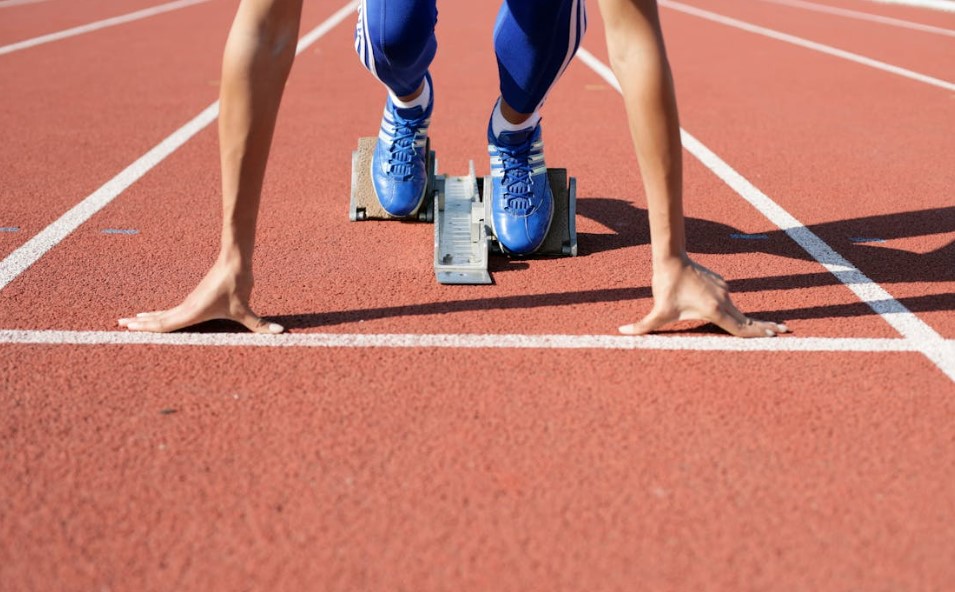 Track and field runner in starting block.