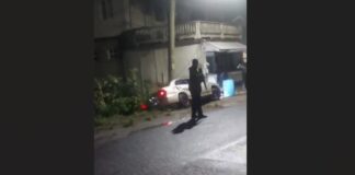 Armed police officer at the scene of police-involved shooting at Anse La Raye.