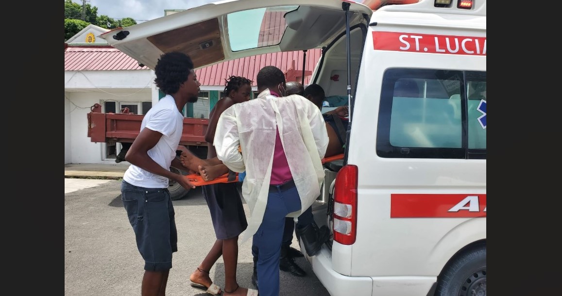 Emergency responder and public spirited citizens lift an injured scooter rider on a stretcher into an ambulance after he sustained injuries in a collision with a car.