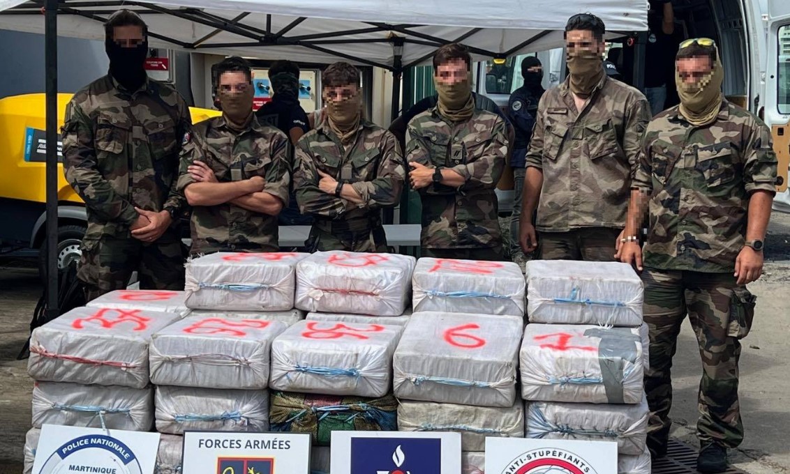 French navy sailors pose with bales of seized cocaine.