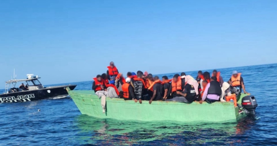 Illegal migrants at sea in overcrowded, makeshift boat.