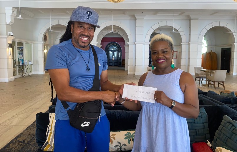 Rise Saint Lucia Inc. Chairman Dr. Venus Cherry accepts monetary donation from founder of Robinson Smiles foundation.