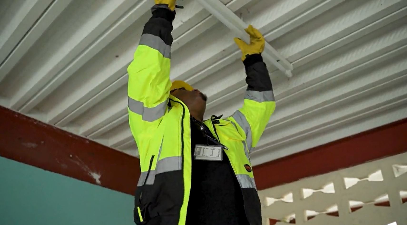 LUCELEC Employee installing light fixture in a school building.